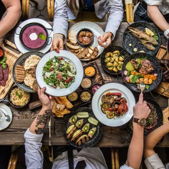 人々が食卓に座り、食べ物を分かち合っている。